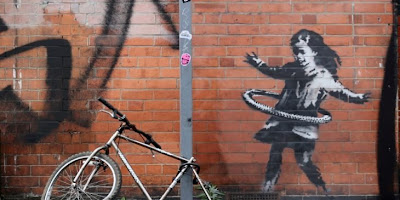 فنان الشارع البريطاني بانكسي يؤكد أنه صاحب لوحة فتاة  » الهولاهوب  »