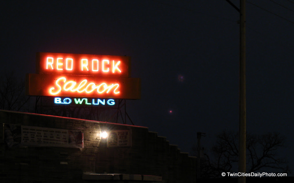 The neon business sign of the Red Rock saloon in Newport, Minnesota is powered on at night.