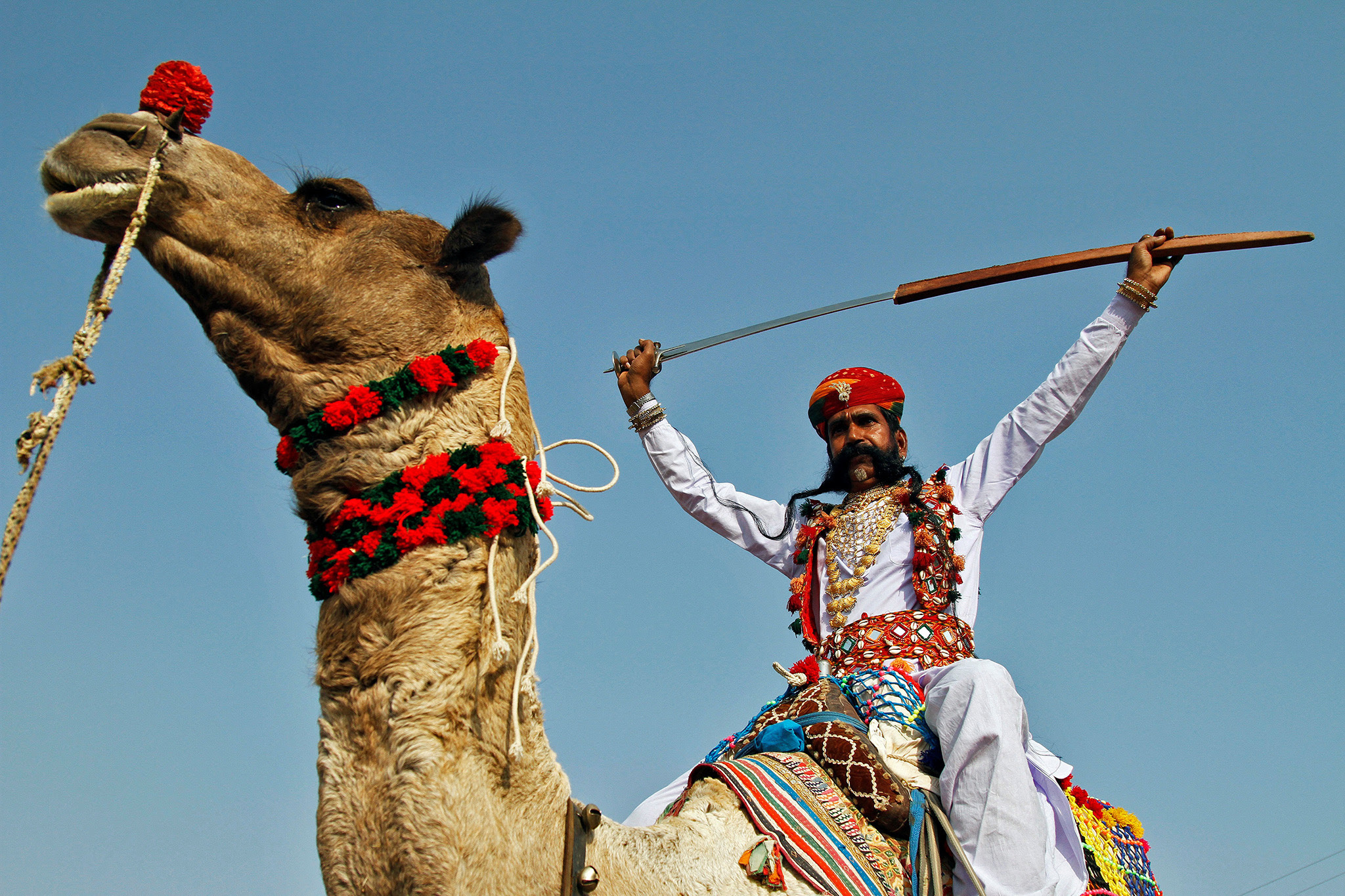 An artist displays a sword on the last day of Pushkar Fair, during which thousands of animals, mainly camels, are brought to the fair to be sold and traded, in the desert state of Rajasthan, India November 14, 2016. REUTERS/Himanshu Sharma TPX IMAGES OF THE DAY