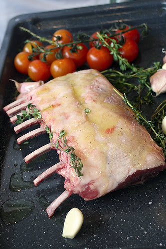 A simple assembly of lamb rack, tomatoes, pink garlic and thyme doused with olive oil