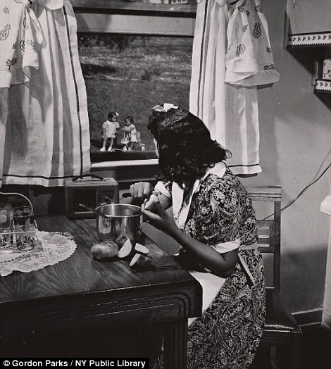 Mother watching her children as she prepares the evening meal in Anacostia, DC Frederick Douglass housing project in 1942