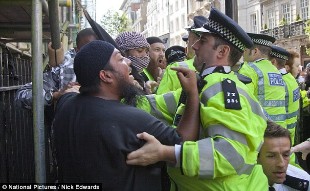 Protesters argue with police officers as they attempt to regain control of the situation in central London