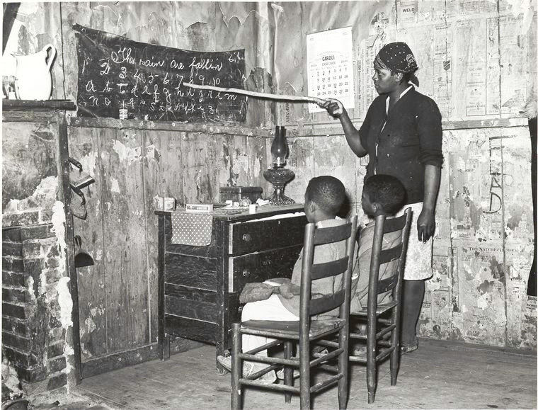 Negro mother teaching children numbers and alphabet in home of sharecropper, Transylvania, Louisiana, January 1939.