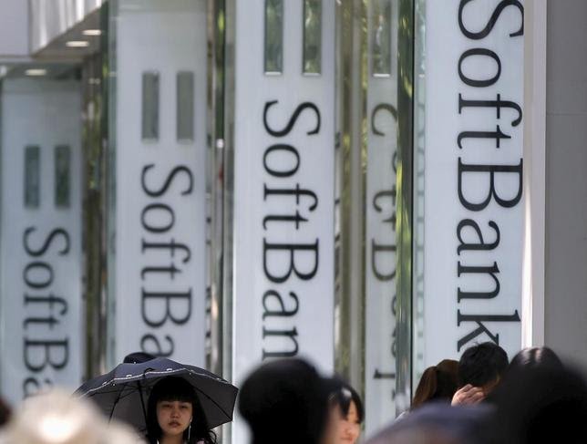 Pedestrians walk past logos of SoftBank Corp in front of its branch in Tokyo May 11, 2015. REUTERS/Toru Hanai