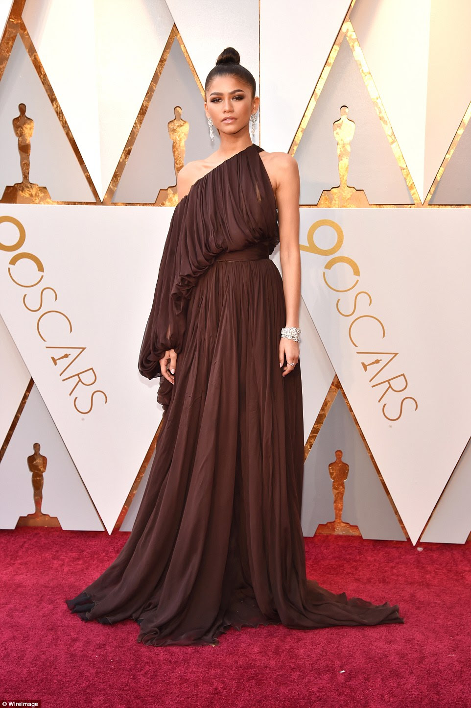 Uma deusa: Zendaya escolheu um vestido de ombro com uma textura plissada com um penteado de chocolate; ela usava suas fechaduras em um nó superior