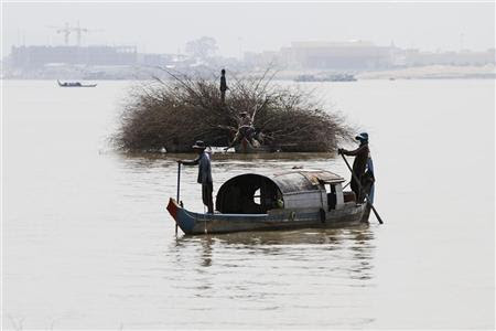Locals manoeuvre their small vessels along the Mekong river in Phnom Penh November 7, 2012. REUTERS/Samrang Pring