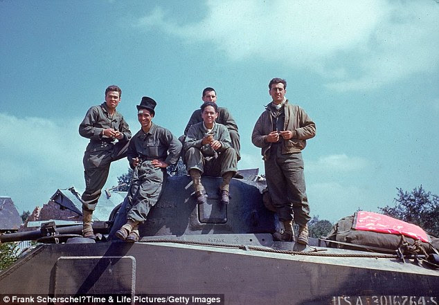 An American tank crew takes a breather on the way through the town of Avranches, Normandy, in the summer of 1944
