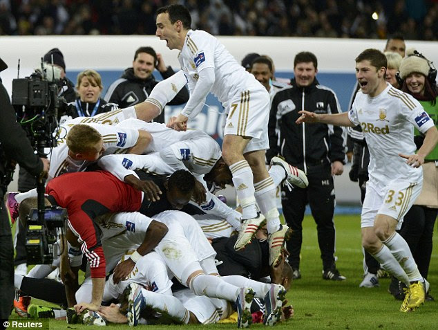 Bundle: Swansea City players pile up in celebration at Wembley