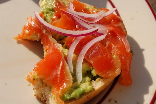 gravlax on a bagel with avocado and red onions