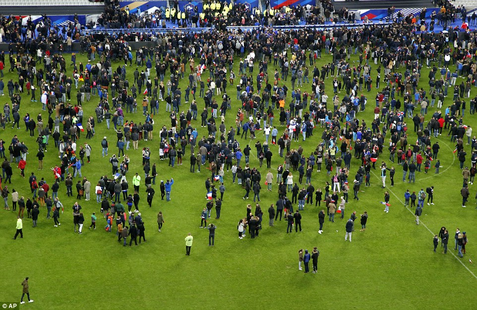 Spectators invade the pitch of the Stade de France stadium after two explosions were heard during the international friendly soccer France against Germany