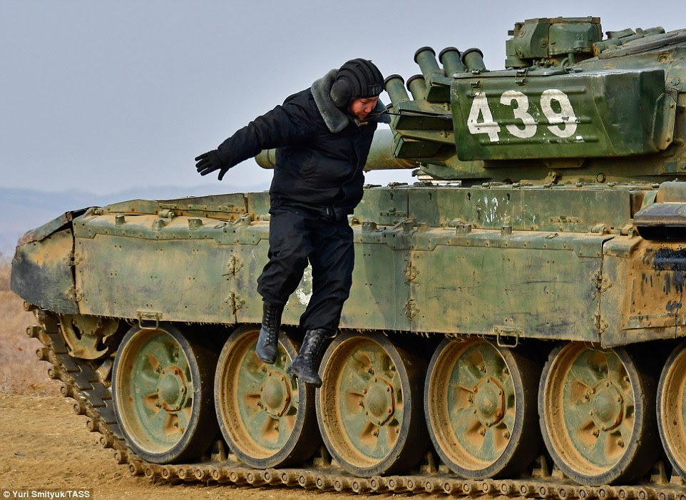Smooth dismount: Another competitor hops down from his tank after completing his race. Nobody has yet been able to defeat the Russians at the proper tournament in the summer 