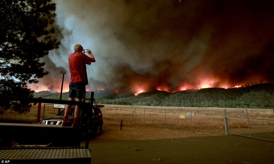 A man snaps a photo as the Valley Fire rolls in to Middletown on the slopes of Cobb Mountain on Saturday 