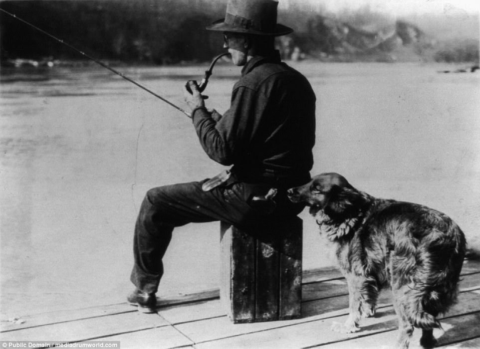 US Federal agents trained 'Hooch Hounds' - dogs who could sniff out liquor. Here one investigates a flask in the back pocket of a man fishing on a pier at the Potomac River 