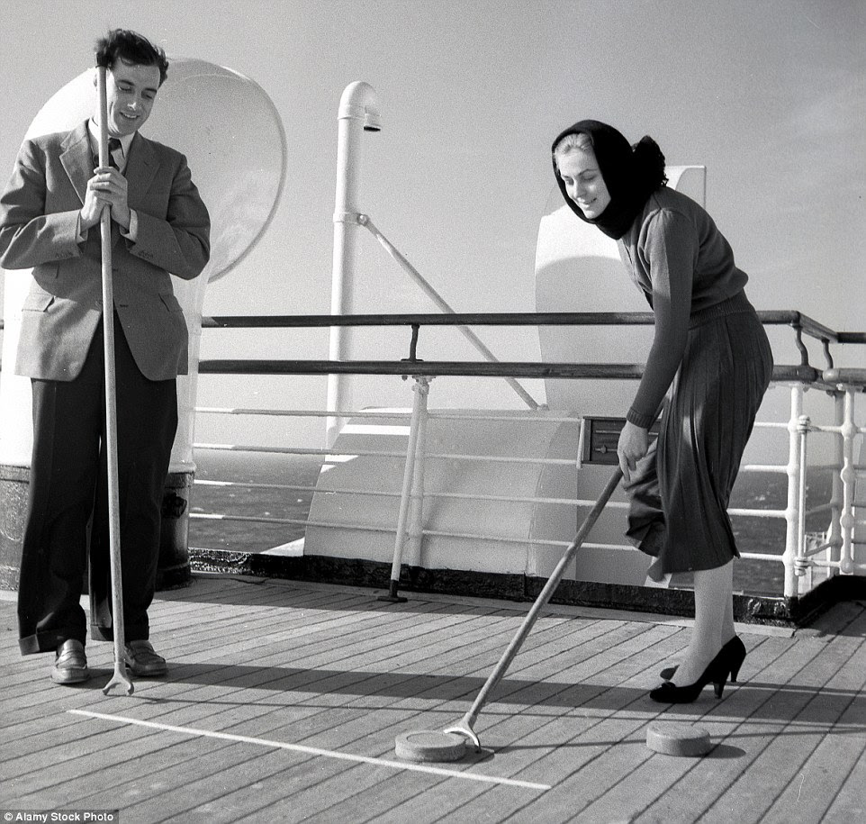 Sporting fun: Two well-dressed passengers on a cruise ship enjoying a deck game of shove the puck in the sun 