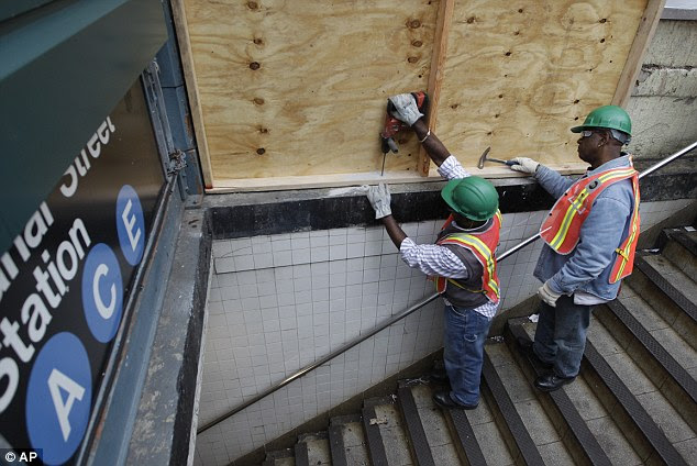 Preparations: Metropolitan Transportation Authority workers cover an entrance to the Canal St. A, C, and E station with plywood to help prevent flooding