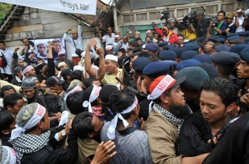 INDONESIA-ATTACK-EXECUTION Indonesian Mobile Brigade Policemen clash with supporters shortly before the funeral of the bodies of Amrozi and Mukhlas in Tenggulun on November 9, 2008. Grief and religious fervour boiled over into calls for revenge here as two brothers executed for their role in the 2002 Bali attacks were buried amid tight security. A crowd of about 500 supporters briefly clashed with police near the family home of 47-year-old Amrozi -- dubbed the "smiling assassin" for his disturbing grin -- and Mukhlas, 48, as their bodies arrived in their east Java village. AFP PHOTO/ADEK BERRY (Photo credit should read ADEK BERRY/AFP/Getty Images)