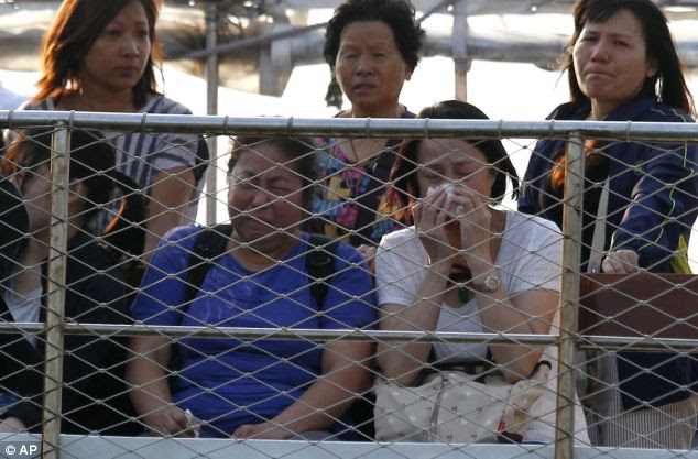Distraught family: Relatives of the victims cry as they pay tribute to the ill-fated people who were aboard the boat