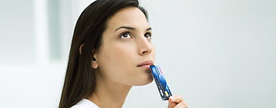 Woman holding credit card up to face, looking up (Getty Images)