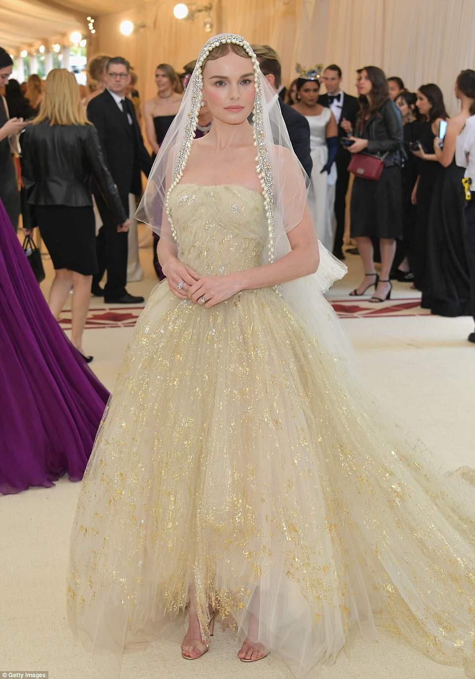 Beleza velada: Kate Bosworth vestiu um vestido dourado e creme com uma grande saia rendada, acrescentando um véu de pérola; ela está vestindo Oscar de la Renta