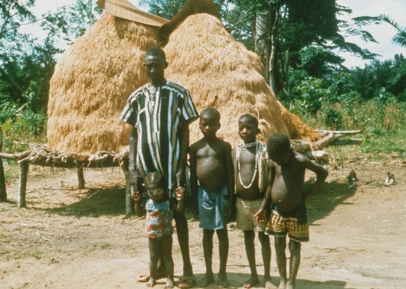 After a day of teaching at Gboveh High School, I would follow jungle trails to surrounding villages and farms. This picture features a Kpelle farmer with his three boys and young daughter. Harvested rice is piled behind the family.