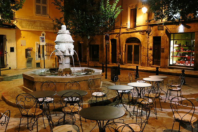 Fountain and restaurant seating in the evening light in Aix-en-Provence, France 