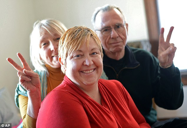 In the spirit: Happy Thanksgiving Reynolds, front, is photographed Sunday with her parents Thora, left and Kelly Reynolds in her Minneapolis home