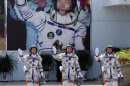 Chinese astronauts Jing Haipeng, Liu Wang and Liu Yang wave during a departure ceremony at Jiuquan Satellite Launch Center