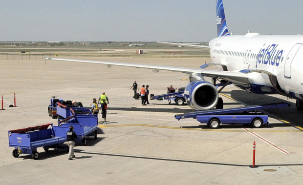 Equipes de segurança vasculham o avião após o pouso inesperado em Amarillo, no Texas, nesta terça-feira (27) (Foto: AP)