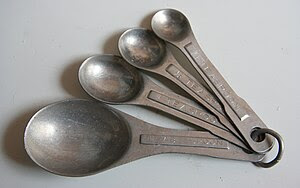 English: Four aluminum measuring spoons on a r...