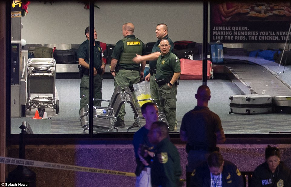 Law enforcement officers examined the crime scene inside the baggage hall on Friday nightÂ