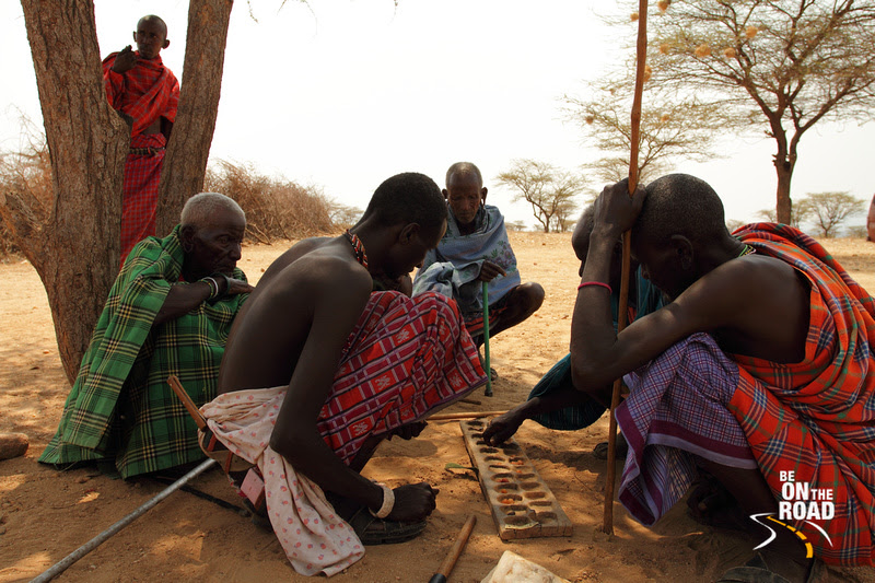 Samburu Elders huddle together under a tree to play a game