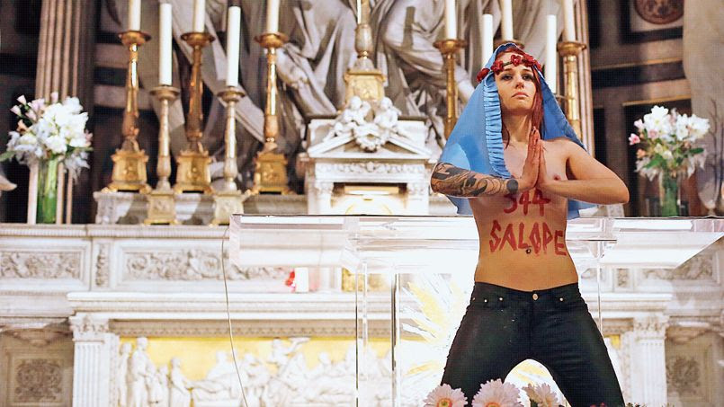 Une jeune femme, membre du collectif féministe Femen, au cours d'une action devant l'autel de l'église de la Madeleine à Paris, le 20 décembre.