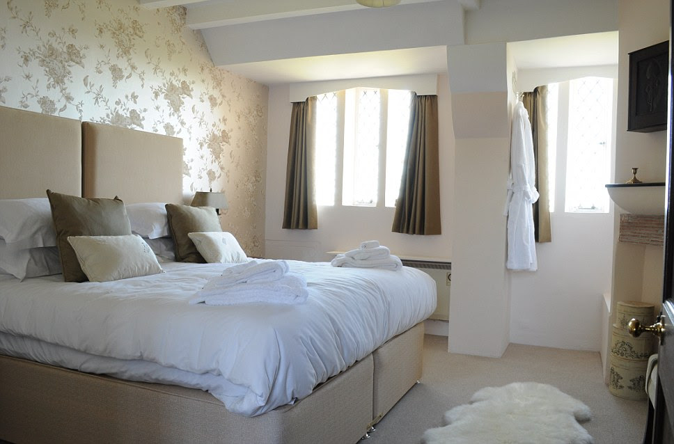 White meets beige in a bedroom at Happisburgh Manor in Norfolk and the wide windows ensure that plenty of light can enter the room
