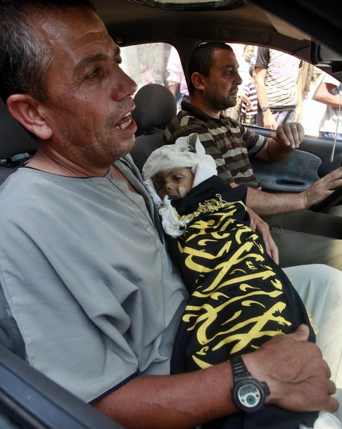 A Palestinian man carries the body of two-year-old boy Islam Qreqa during a funeral in Gaza City