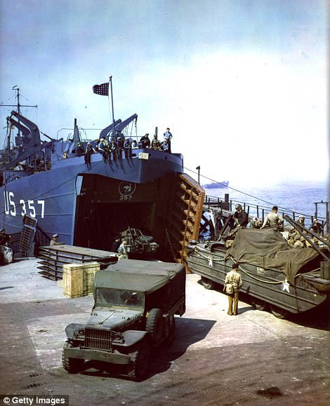 DUKWs, amphibious trucks useful for beach landings, are loaded onto an LST (Landing Ship - Tank) during preparations for the D-Day invasion