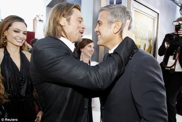 Bromance: Brad cumprimentou seu amigo George Clooney com um abraço quente, enquanto Angelina olhava com um sorriso
