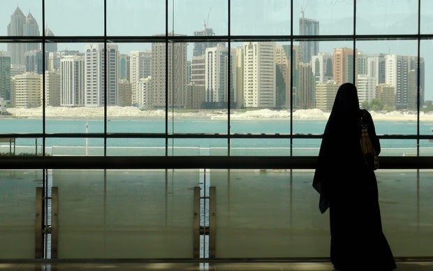 Mulher olha para prédios de Abu Dhabi, nos Emirados Árabes Unidos (Foto: Flávia Mantovani/G1)