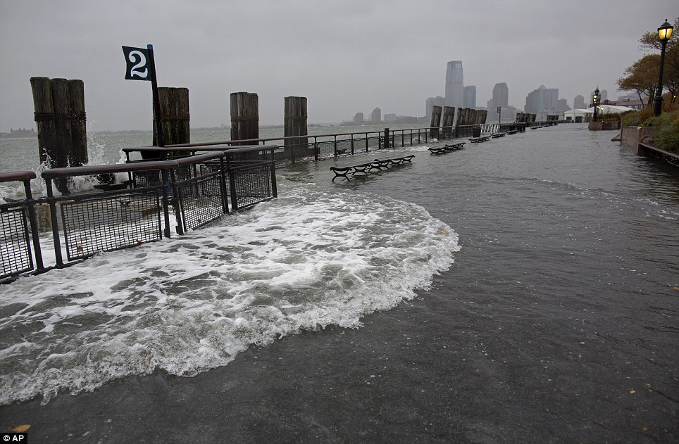 Coming through: Waves wash over the sea wall near high tide at Battery Park in Manhattan, New York, on Monday, with New Jersey in the background