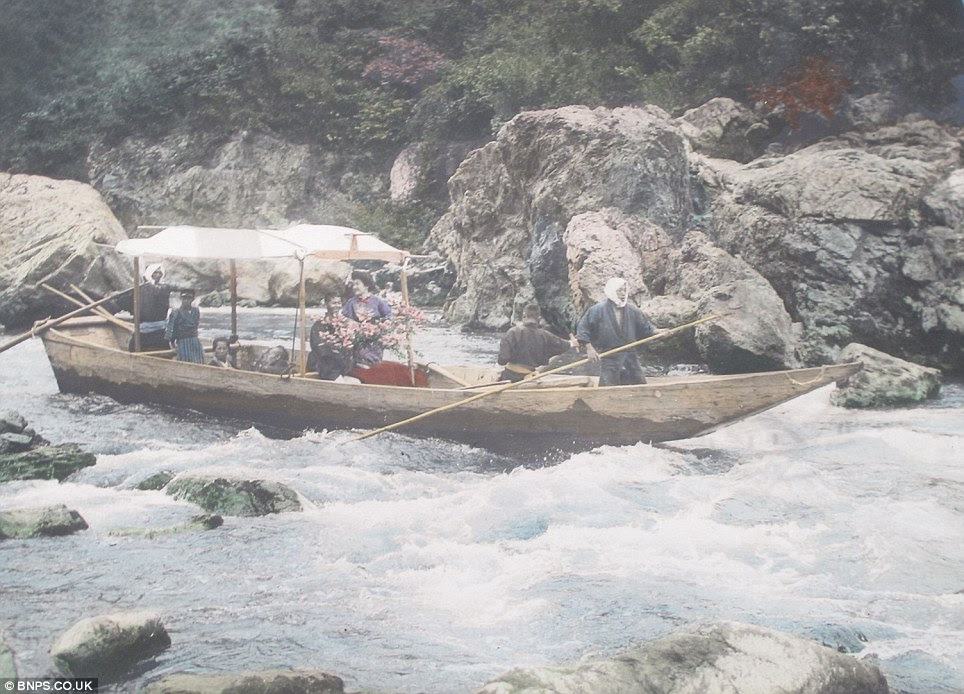 Braving the rapids: Ladies travelling along a dangerous mountain river in a wooden boat