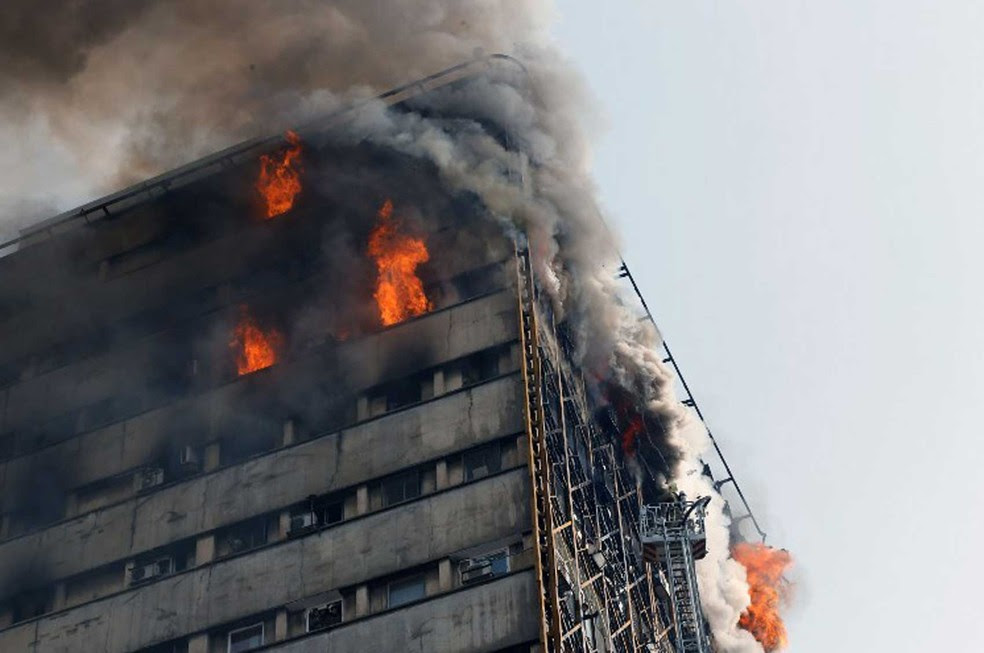 Bombeiros combatiam incêndio quando o prédio desabou  (Foto: STR / AFP)