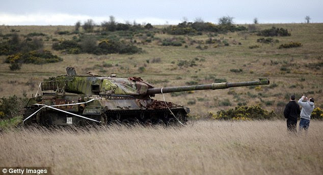 Visitors: People stop to take pictures of tanks left beside the road in Imber