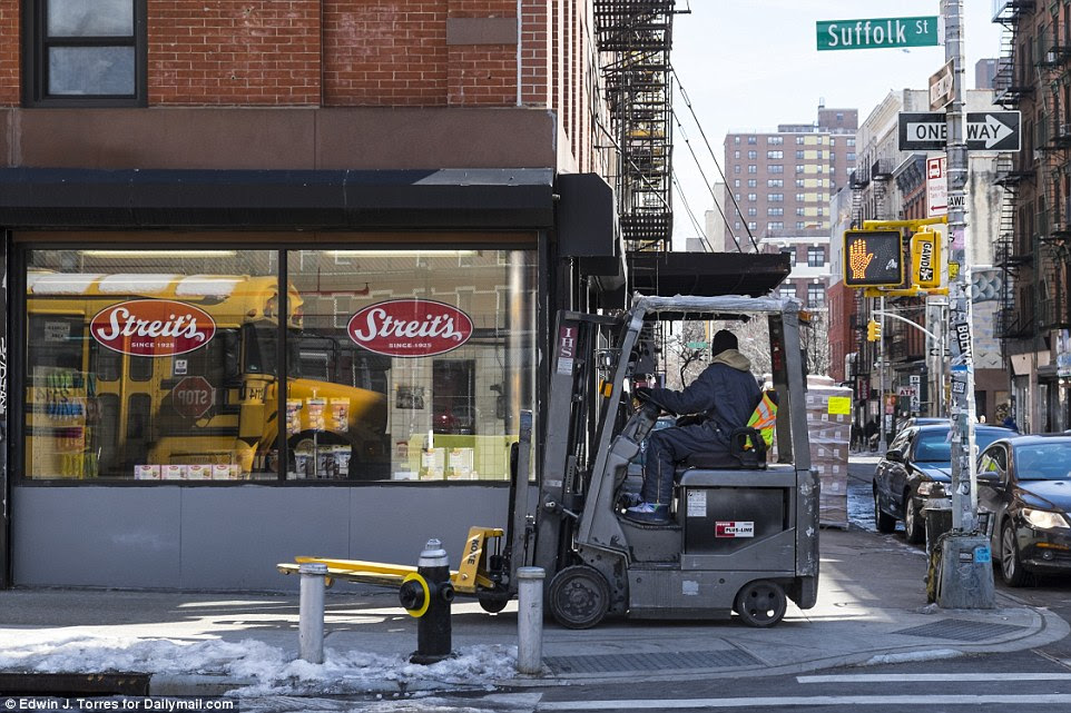 This is the same location from Todd Webb's 1946 photograph on Suffolk and Hester streets where shoppers purchase goods from a street cart in front of the corner store