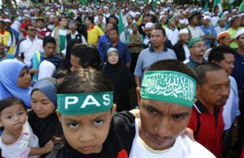 An opposition supporters and his daughter wear Pan-Malaysian Islamic Party (PAS) head bands during a nomination in Taiping, Northern state of Perak ,300 kilometers (187 miles) from Kuala Lumpur, Sunday, March 29 2009. Malaysian politicians launched their campaign Sunday for three legislative seats in special elections seen as a crucial test for the ruling party's new leaders. (AP Photo