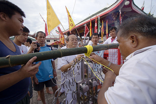 Tying lanterns to the Go Teng pole