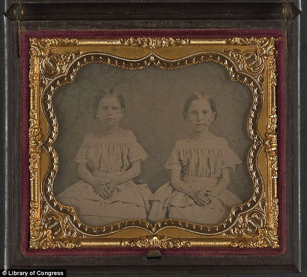 Sisters? Two unidentified girls wearing identical frocks pose for a picture