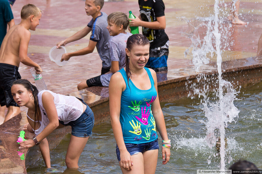 Девушки купаются в фонтане в мокрой одежде