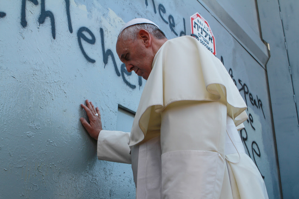 Pope Francis prays against the security barrier at Bethlehem, May 25, 2014 (photo credit: Nour Shamaly/Flash90)
