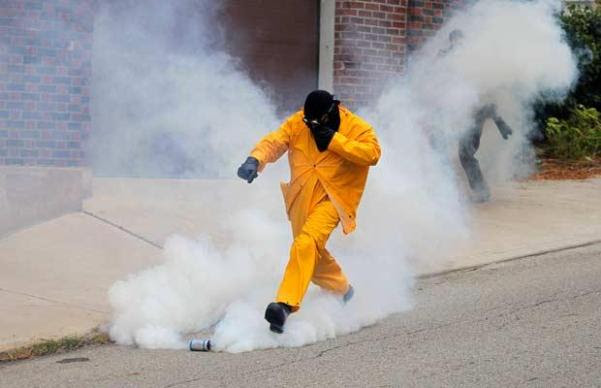 A demonstrator kicks a tear gas canister fired by police A demonstrator kicks a tear gas canister fired by police