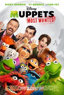 Group picture of the Muppets with two men and a woman standing behind them. In the background is a gray globe of the world.