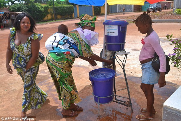 Limpeza: mulheres guineenses lavar as mãos na entrada do hospital Sino-guineense de Kipe no município Ratoma, onde a primeira pessoa infectada com o vírus Ebola foi tratado em Conakry